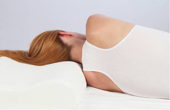 Memory foam pillow supporting shoulder blades during side sleeping